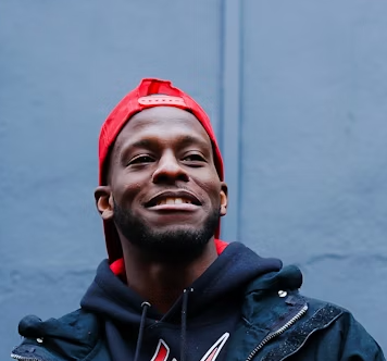 Smiling man in red cap.